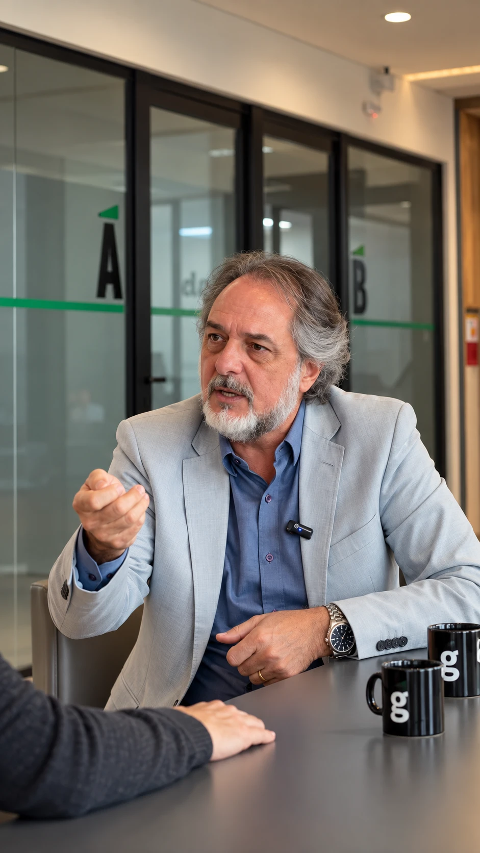 Guillermo Colombo conversando com uma pessoa em uma sala de reunião